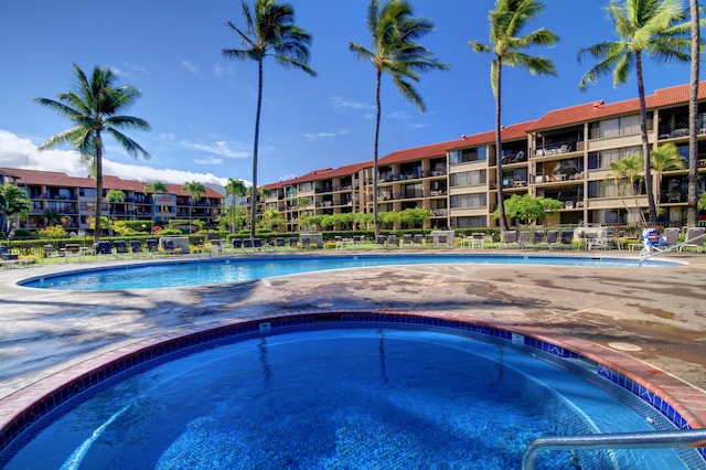 view of swimming pool featuring a hot tub