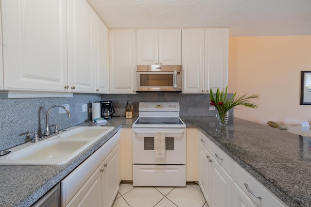 kitchen with a sink, white cabinetry, stainless steel microwave, and white electric range