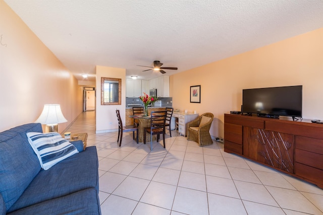 living room featuring light tile patterned floors, a textured ceiling, and a ceiling fan