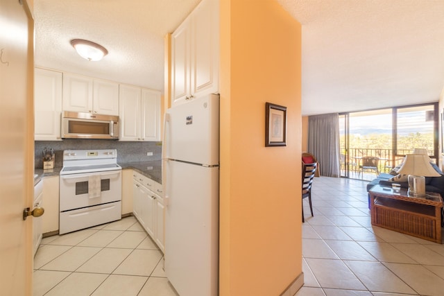 kitchen featuring floor to ceiling windows, backsplash, open floor plan, white cabinetry, and white appliances