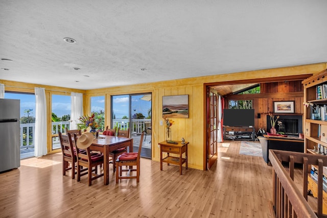 dining room featuring wood walls and light wood finished floors