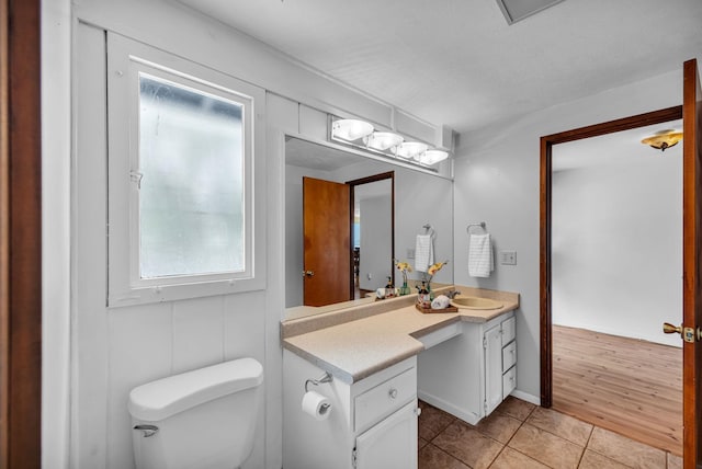 half bath featuring toilet, tile patterned floors, and vanity