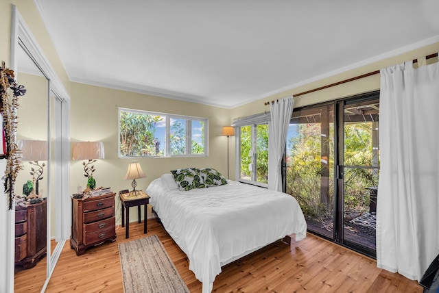 bedroom with light wood-style flooring, access to exterior, and ornamental molding