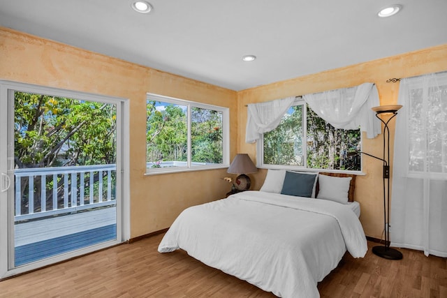 bedroom with access to outside, wood finished floors, baseboards, and recessed lighting