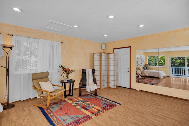 living area with wood finished floors, attic access, baseboards, and recessed lighting
