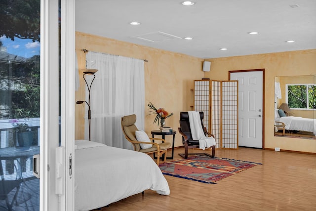 bedroom featuring wood finished floors, attic access, baseboards, and recessed lighting