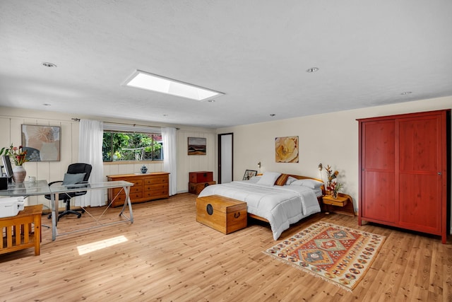 bedroom featuring light wood-style floors and a skylight