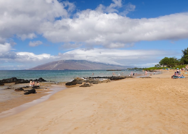 view of water feature with a mountain view and a view of the beach