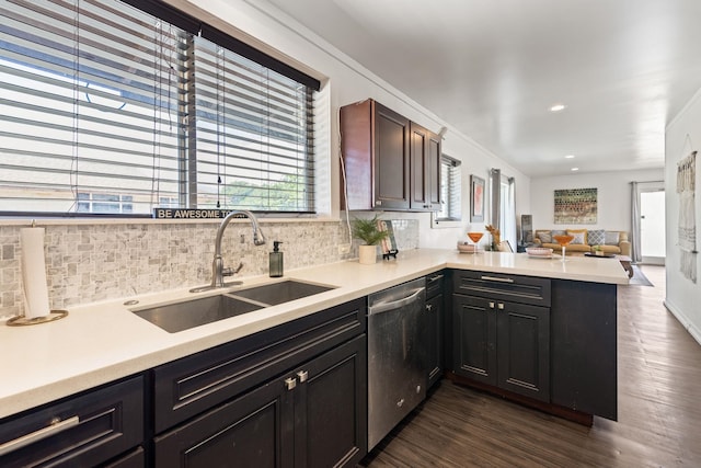 kitchen with dark wood-style floors, a peninsula, a sink, stainless steel dishwasher, and backsplash