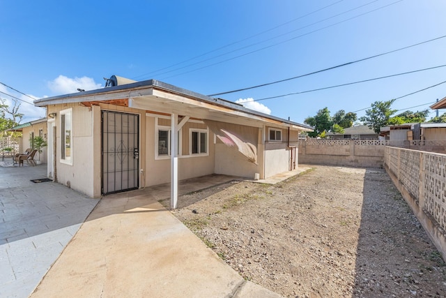 back of property with stucco siding, a fenced backyard, and a patio area