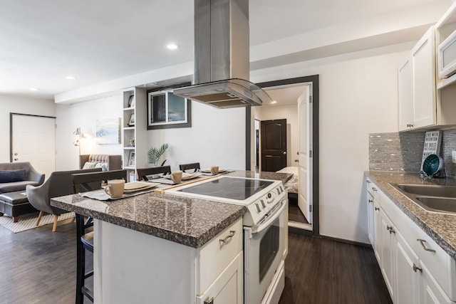 kitchen with decorative backsplash, island exhaust hood, electric range, white cabinetry, and dark wood-style flooring