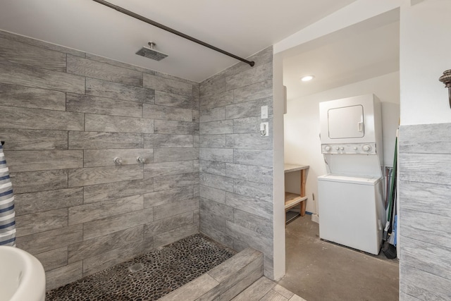 bathroom with stacked washer and clothes dryer, tiled shower, and concrete floors