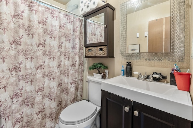 bathroom with curtained shower, toilet, and vanity