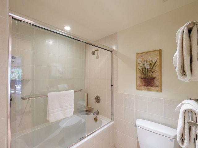 bathroom with shower / bath combination with glass door and toilet