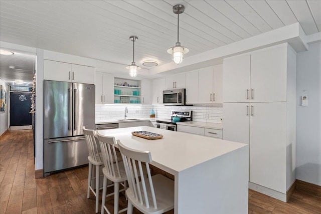 kitchen with dark hardwood / wood-style flooring, white cabinetry, appliances with stainless steel finishes, and a center island