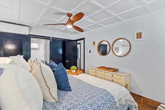 bedroom featuring a wall mounted AC, a barn door, coffered ceiling, hardwood / wood-style flooring, and ceiling fan