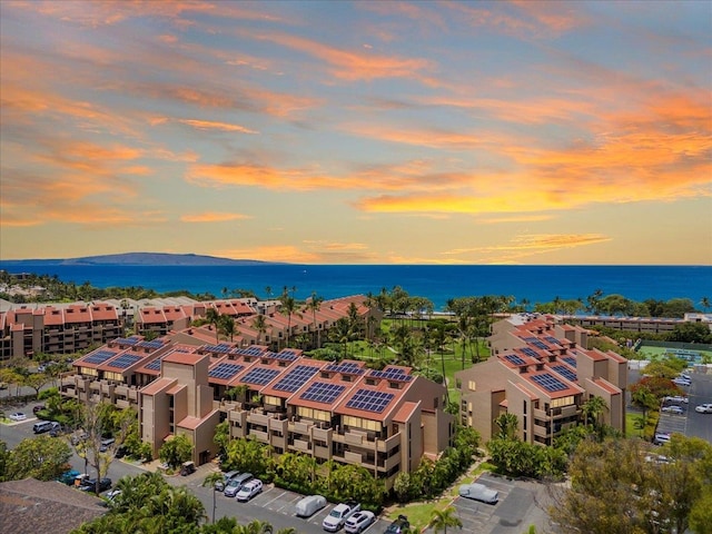 aerial view at dusk featuring a water view