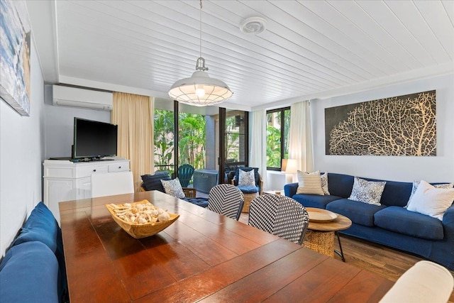 dining area with wood-type flooring, an AC wall unit, and a wall of windows