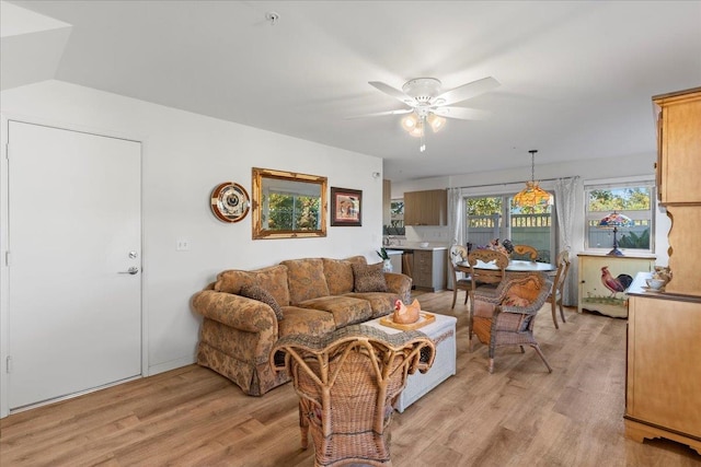 living room featuring light hardwood / wood-style floors, vaulted ceiling, and ceiling fan