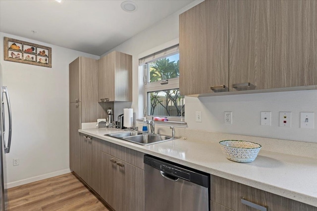 kitchen with light wood-type flooring, sink, and appliances with stainless steel finishes