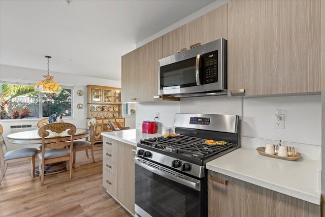 kitchen featuring pendant lighting, light hardwood / wood-style floors, stainless steel appliances, and light brown cabinetry