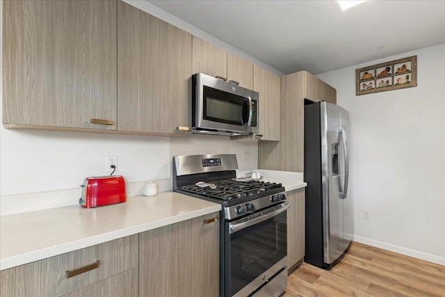 kitchen featuring light brown cabinets, light hardwood / wood-style floors, and appliances with stainless steel finishes