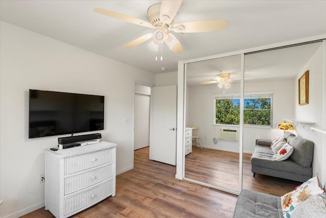 living room featuring a wall mounted AC, ceiling fan, and hardwood / wood-style floors