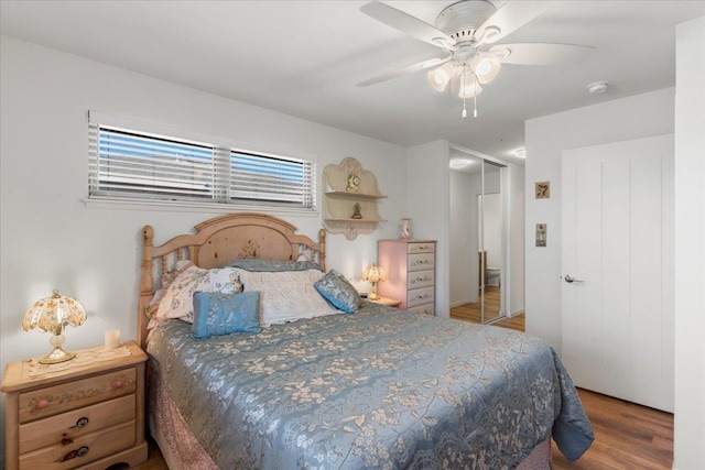 bedroom with a closet, hardwood / wood-style flooring, and ceiling fan