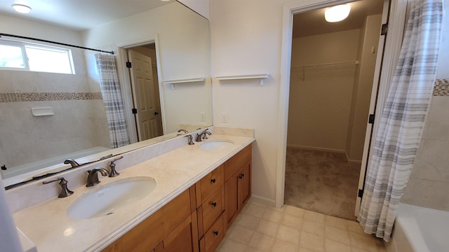 full bath featuring double vanity, shower / bath combination with curtain, baseboards, and a spacious closet
