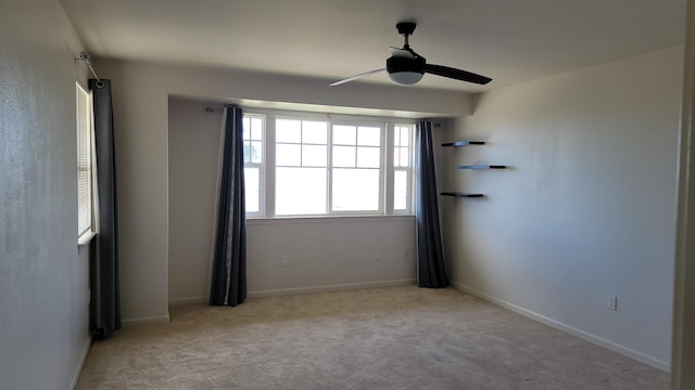 spare room with carpet, a ceiling fan, and baseboards