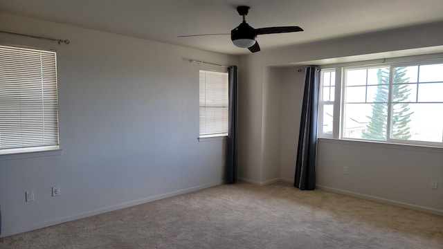 carpeted empty room with ceiling fan and baseboards