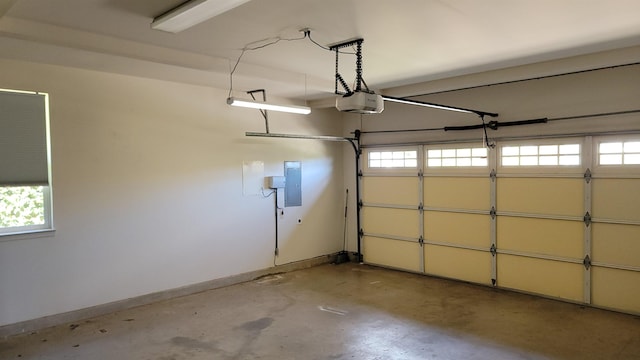 garage with a garage door opener, electric panel, and baseboards