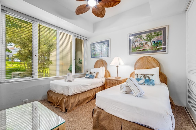 bedroom featuring a tray ceiling, ceiling fan, and carpet