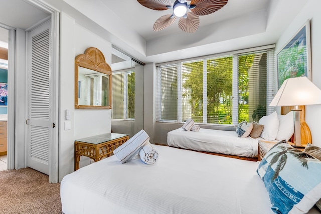 bedroom with ceiling fan, light colored carpet, and a closet