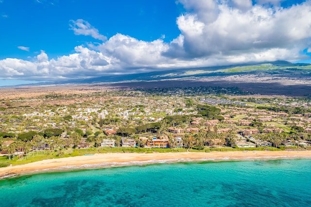 drone / aerial view featuring a water and mountain view and a beach view