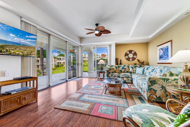 living room with dark hardwood / wood-style flooring and ceiling fan