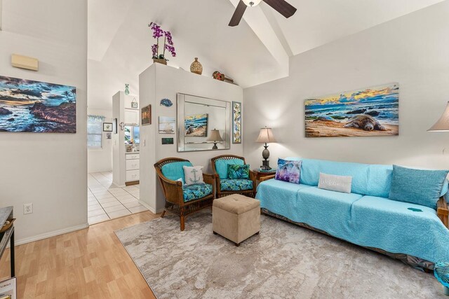 living area with lofted ceiling, hardwood / wood-style floors, and ceiling fan