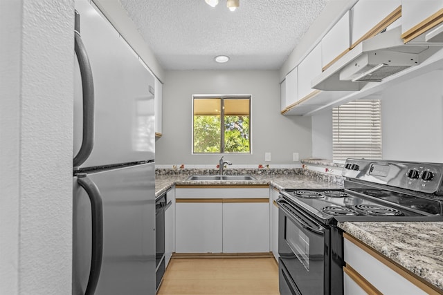 kitchen featuring exhaust hood, sink, white cabinetry, and black appliances