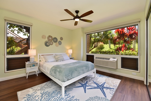 bedroom with a wall mounted AC, dark hardwood / wood-style flooring, and ceiling fan