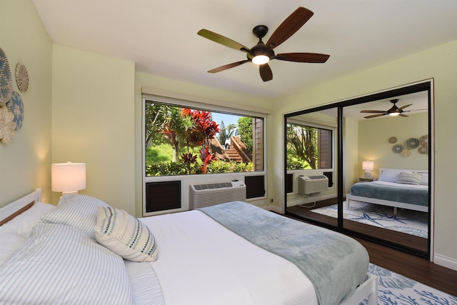 bedroom with a closet, hardwood / wood-style flooring, ceiling fan, and cooling unit