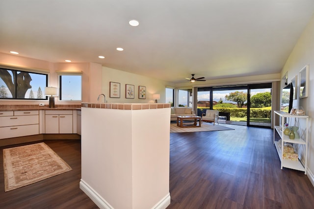 kitchen featuring ceiling fan, tile counters, dark hardwood / wood-style flooring, kitchen peninsula, and white cabinets