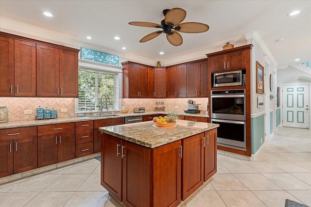 kitchen featuring light stone counters, backsplash, appliances with stainless steel finishes, ornamental molding, and sink