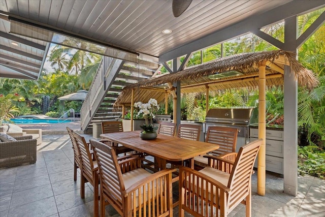 view of patio featuring ceiling fan, exterior kitchen, and a grill