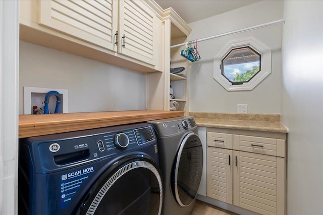 clothes washing area with washer and clothes dryer, hardwood / wood-style flooring, and cabinets