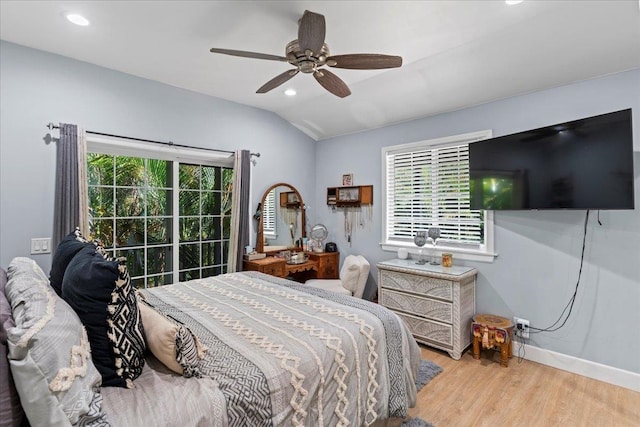 bedroom featuring light hardwood / wood-style flooring, multiple windows, lofted ceiling, and ceiling fan