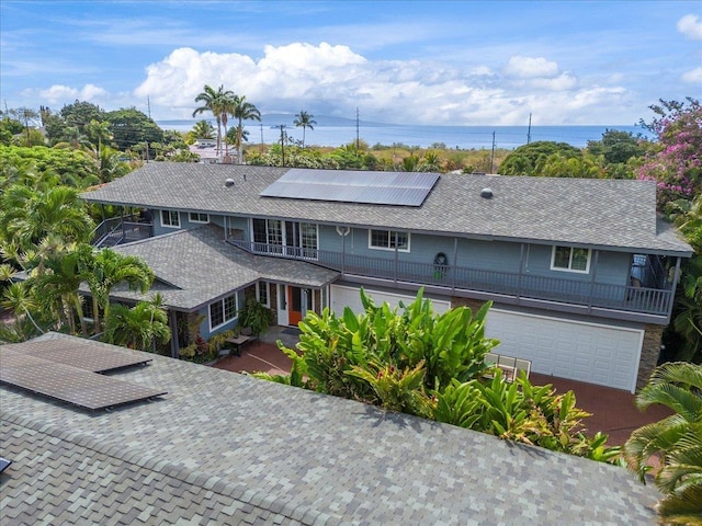440 Mikioi Pl, Kihei, HI 96753 - view of front of home with a balcony, solar panels, a garage, and a shingled roof