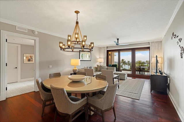 dining room featuring ornamental molding, dark wood-type flooring, and a textured ceiling