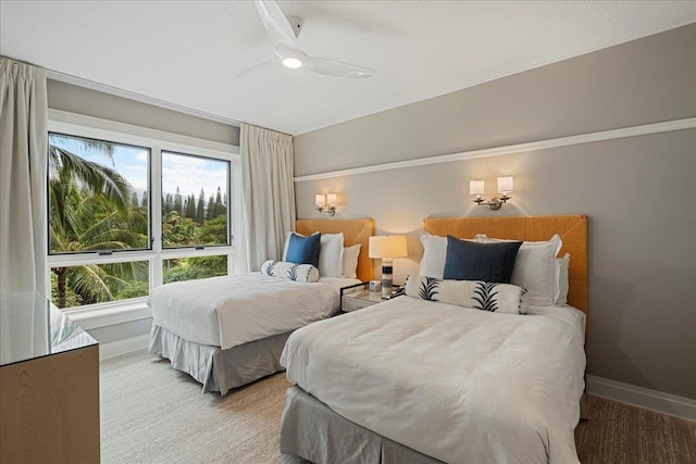 bedroom with light carpet, ceiling fan, and baseboards