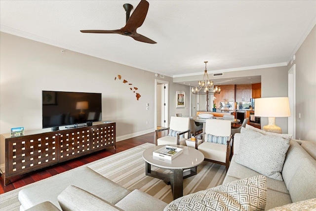 living room featuring ceiling fan with notable chandelier, ornamental molding, wood finished floors, and baseboards