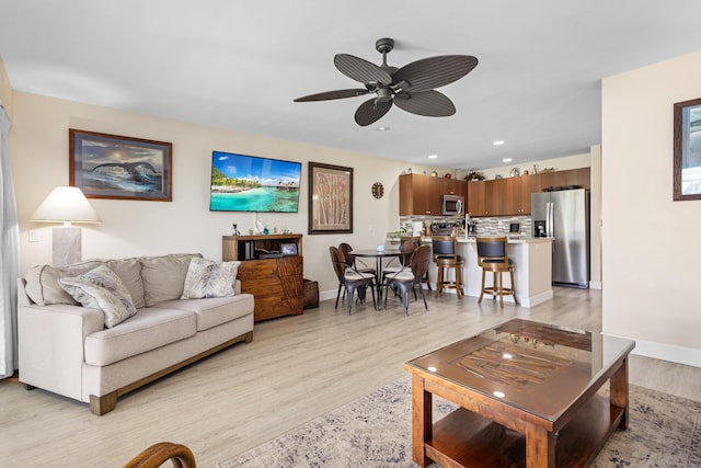 living room featuring ceiling fan and light wood-type flooring